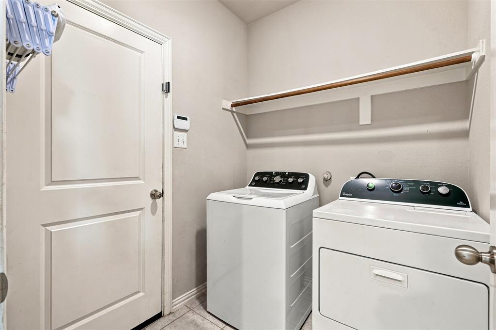 1321 Raleigh Path Denton, TX 76208 - Photo 29 of 35 Dedicated laundry area featuring a white paneled door, light-toned walls, and a built-in shelving unit with a hanging rod