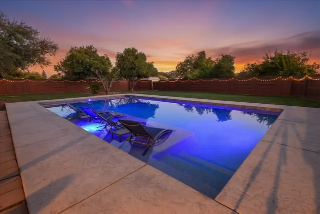 a view of swimming pool with outdoor seating and yard in back