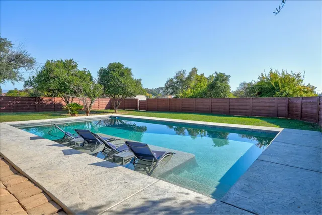 an outdoor space with swimming pool and furniture