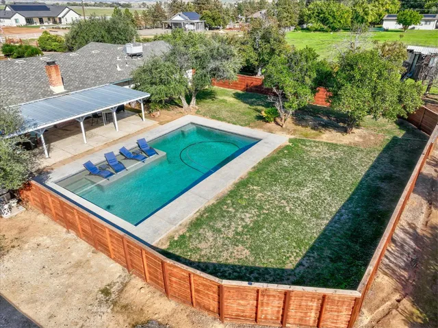 an aerial view of a house with a garden and swimming pool