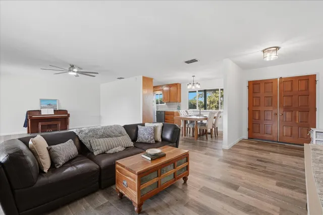 a living room with furniture and a wooden floor