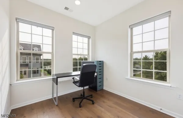 a view of a workspace with furniture and a window