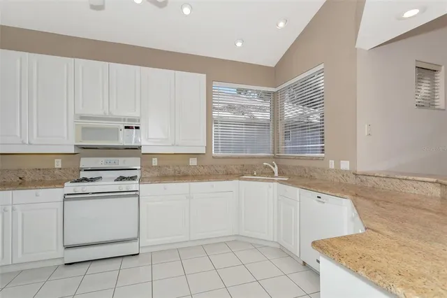 a kitchen with granite countertop white cabinets stainless steel appliances and sink