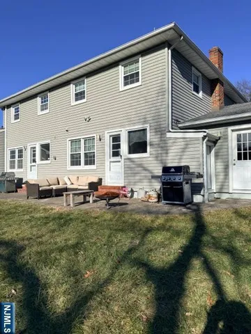 a backyard of a house with table and chairs with wooden floor