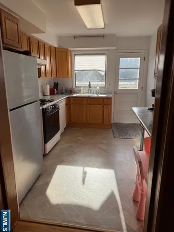 a kitchen with stainless steel appliances granite countertop a refrigerator sink and white cabinets