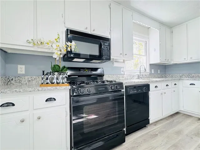 a kitchen with granite countertop a sink and a stove top oven