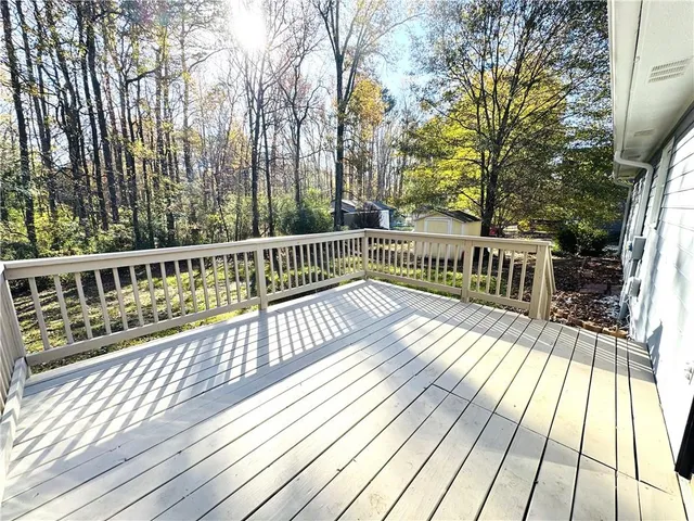a view of deck with wooden floor and fence next to a yard