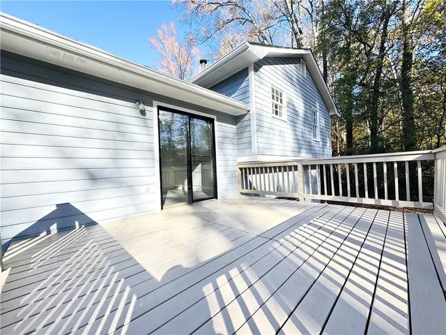 a view of a house with a big yard potted plants and large tree