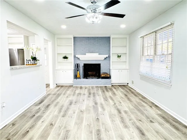 a view of an empty room with window and fire place