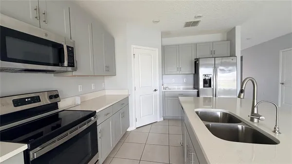 a kitchen with a sink a microwave and cabinets