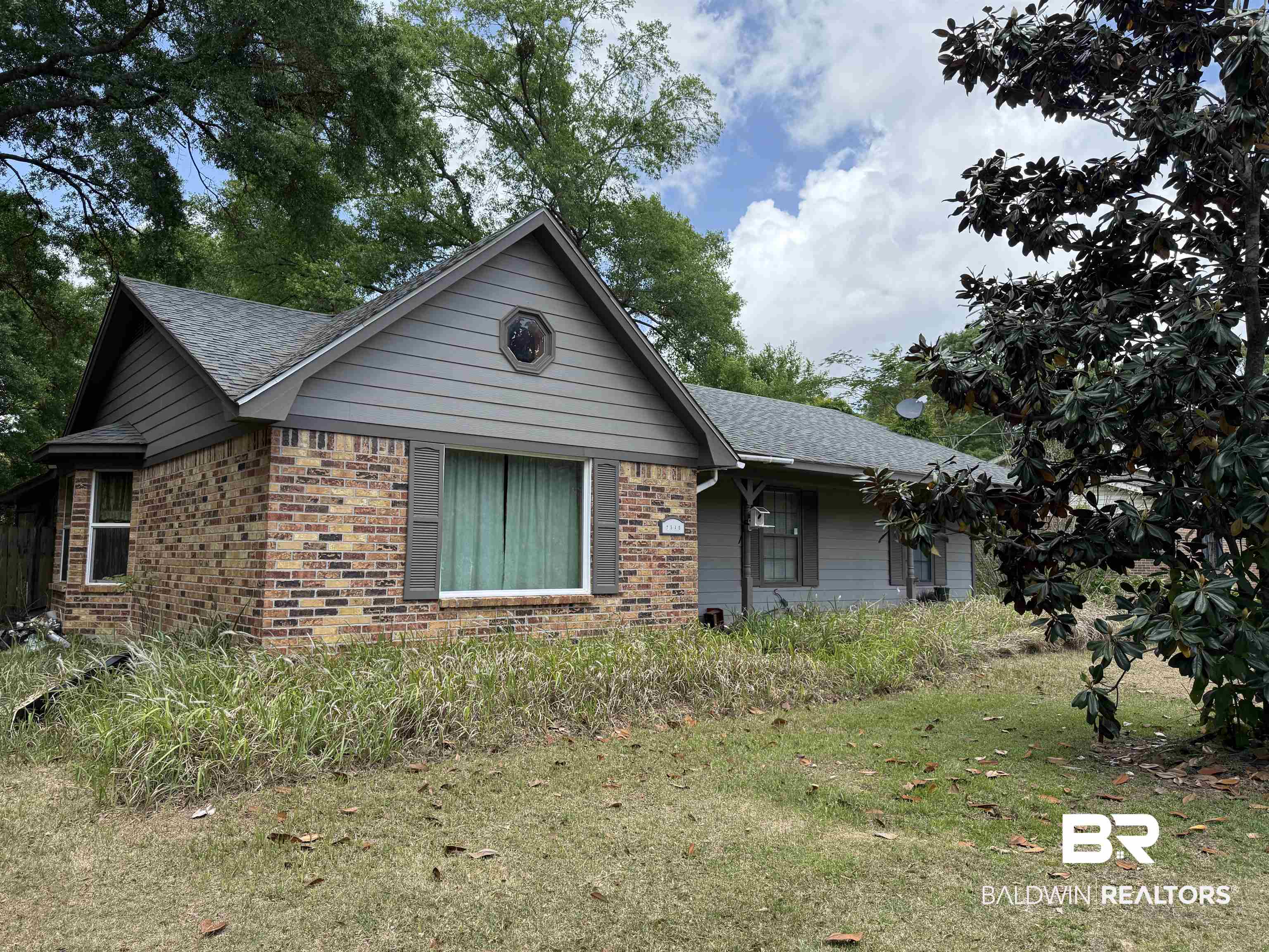 7540 Paddock Drive Theodore, AL 36582 - Photo 1 of 4 View of front of house with a front lawn, a shingled roof, and brick siding