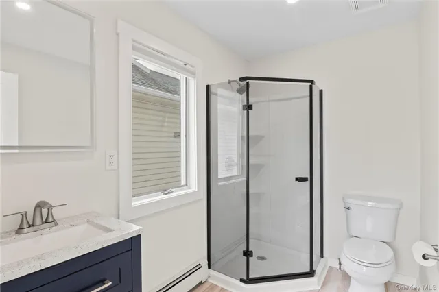 a bathroom with a shower sink vanity and toilet