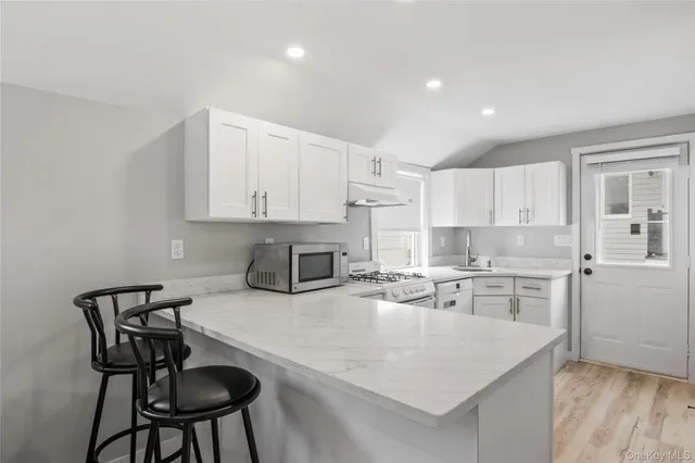 a kitchen with granite countertop white cabinets and appliances