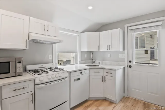 a kitchen with cabinets appliances a sink and a counter top space