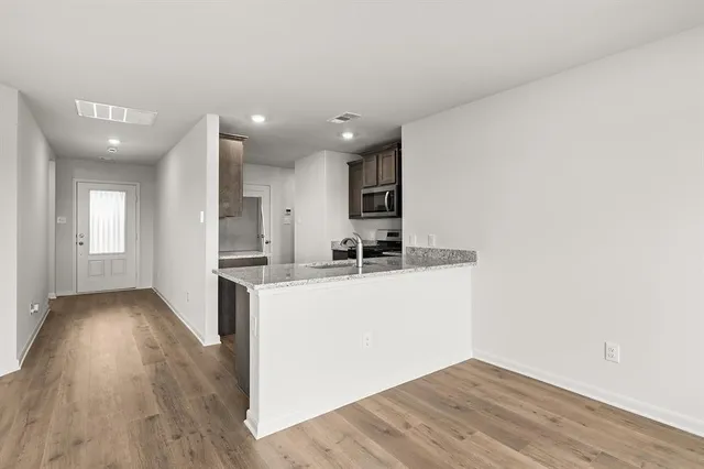 a view of kitchen and hall with wooden floor