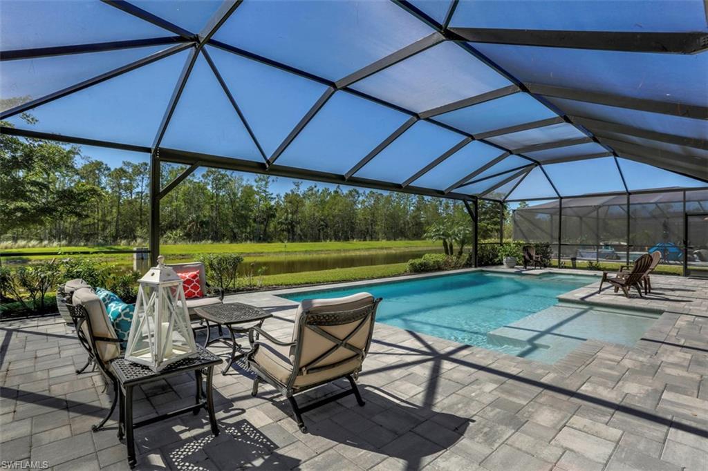 7005 Live Oak Drive Naples, FL 34114 - Photo 22 of 24 a view of a table and chairs under an umbrella