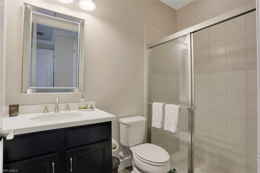 7005 Live Oak Drive Naples, FL 34114 - Photo 5 of 24 a bathroom with a sink mirror vanity and toilet