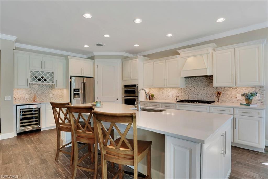 7005 Live Oak Drive Naples, FL 34114 - Photo 7 of 24 a kitchen with a table a stove a cabinets and white appliances