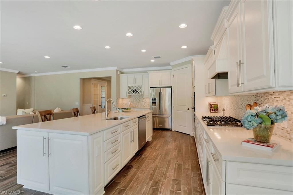 7005 Live Oak Drive Naples, FL 34114 - Photo 8 of 24 a large white kitchen with stainless steel appliances and white cabinets