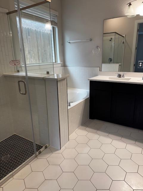 1432 Ridge Runner Drive Georgetown, TX 78628 - Photo 14 of 27 Bathroom featuring a low entry shower stall, double vanity, and a garden tub
