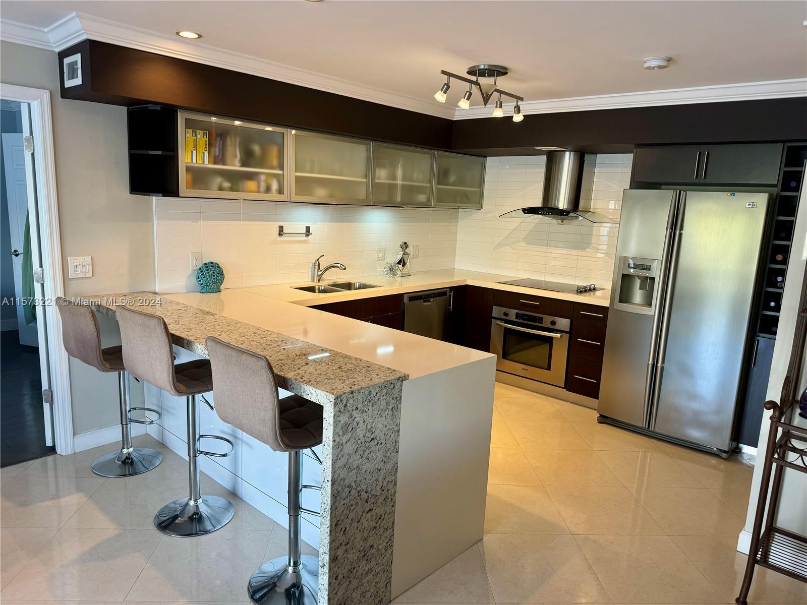 a kitchen with stainless steel appliances kitchen island a table chairs in it and wooden floors