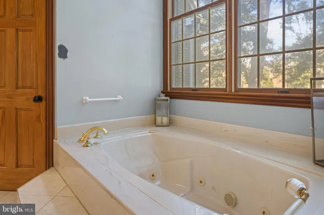 a spacious bathroom with a tub sink and mirror