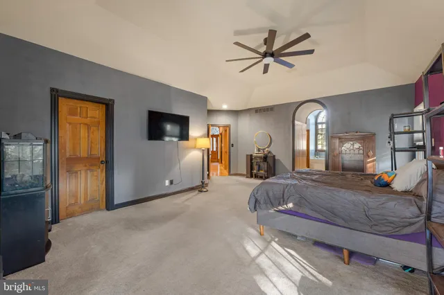 a spacious bedroom with a bed and a chandelier