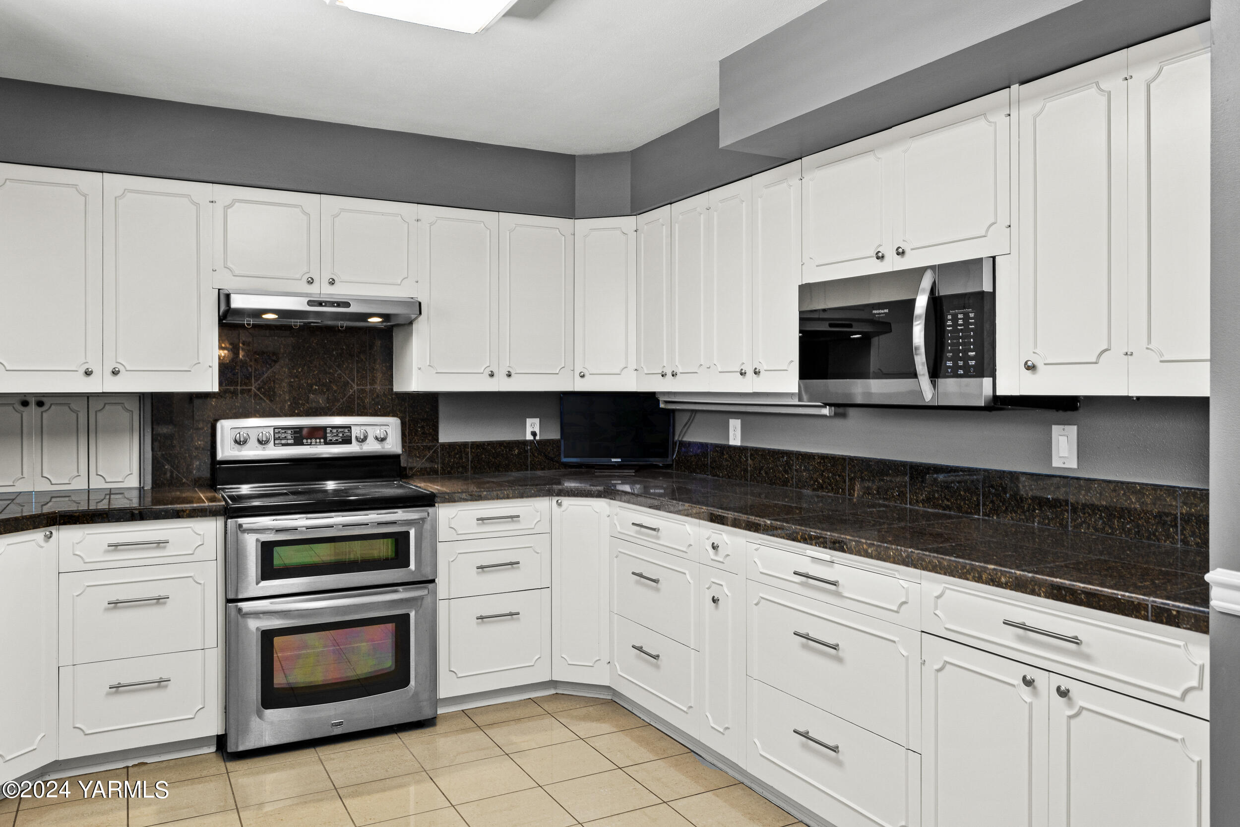 531 McDonald Road Toppenish, WA 98948 - Photo 16 of 78 a kitchen with granite countertop white cabinets and stainless steel appliances