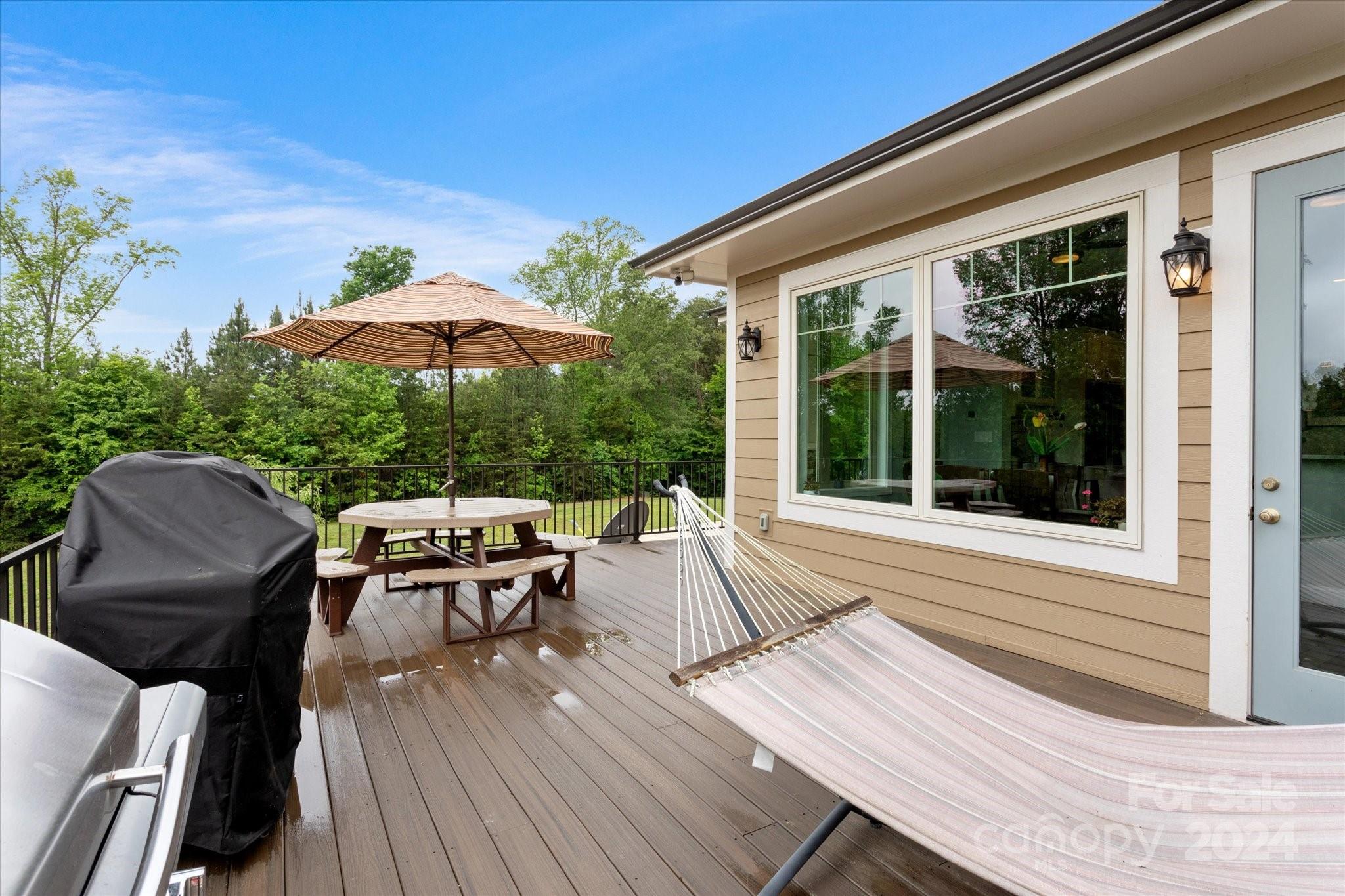 464 Hooper Creek Road Tryon, NC 28782 - Photo 23 of 24 a view of a patio with table and chairs under an umbrella with wooden floor