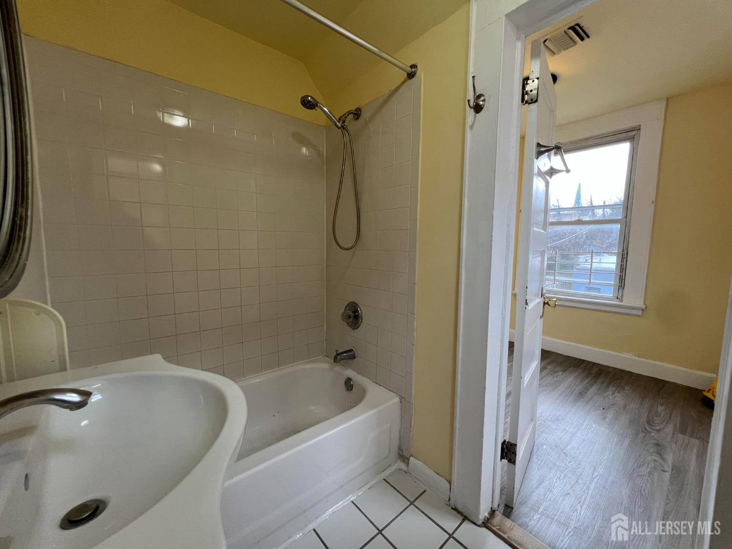109 Washington Street, Unit 2 Perth Amboy, NJ 08861 - Photo 11 of 15 a bathroom with a tub a window and a shower