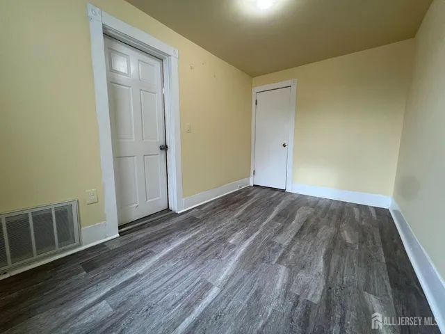 a view of a room with wooden floor and entryway