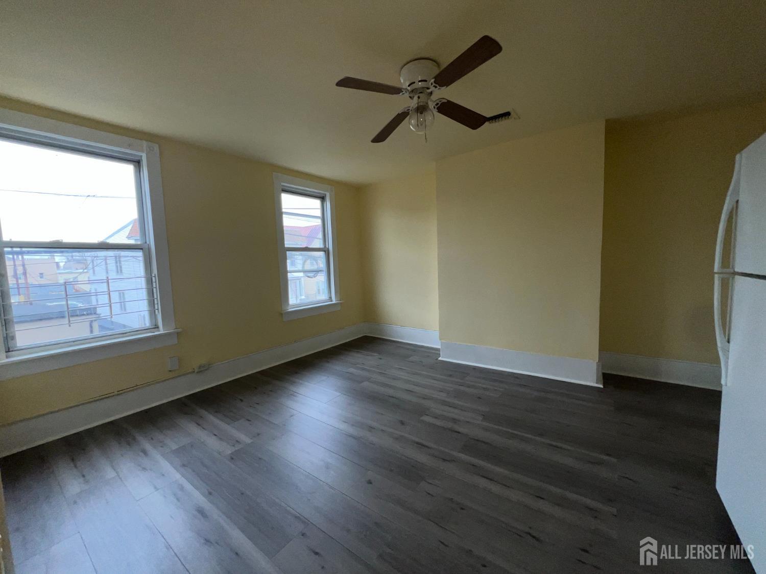 109 Washington Street, Unit 2 Perth Amboy, NJ 08861 - Photo 3 of 15 a view of empty room with wooden floor and fan