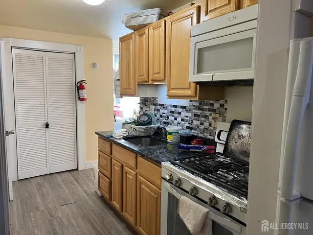 a kitchen with stainless steel appliances granite countertop a sink stove and cabinets