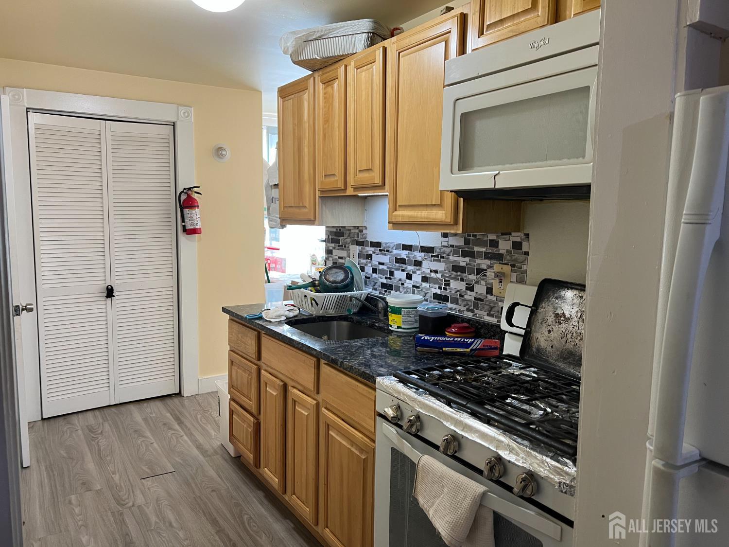 109 Washington Street, Unit 2 Perth Amboy, NJ 08861 - Photo 5 of 12 a kitchen with stainless steel appliances granite countertop a stove and a microwave