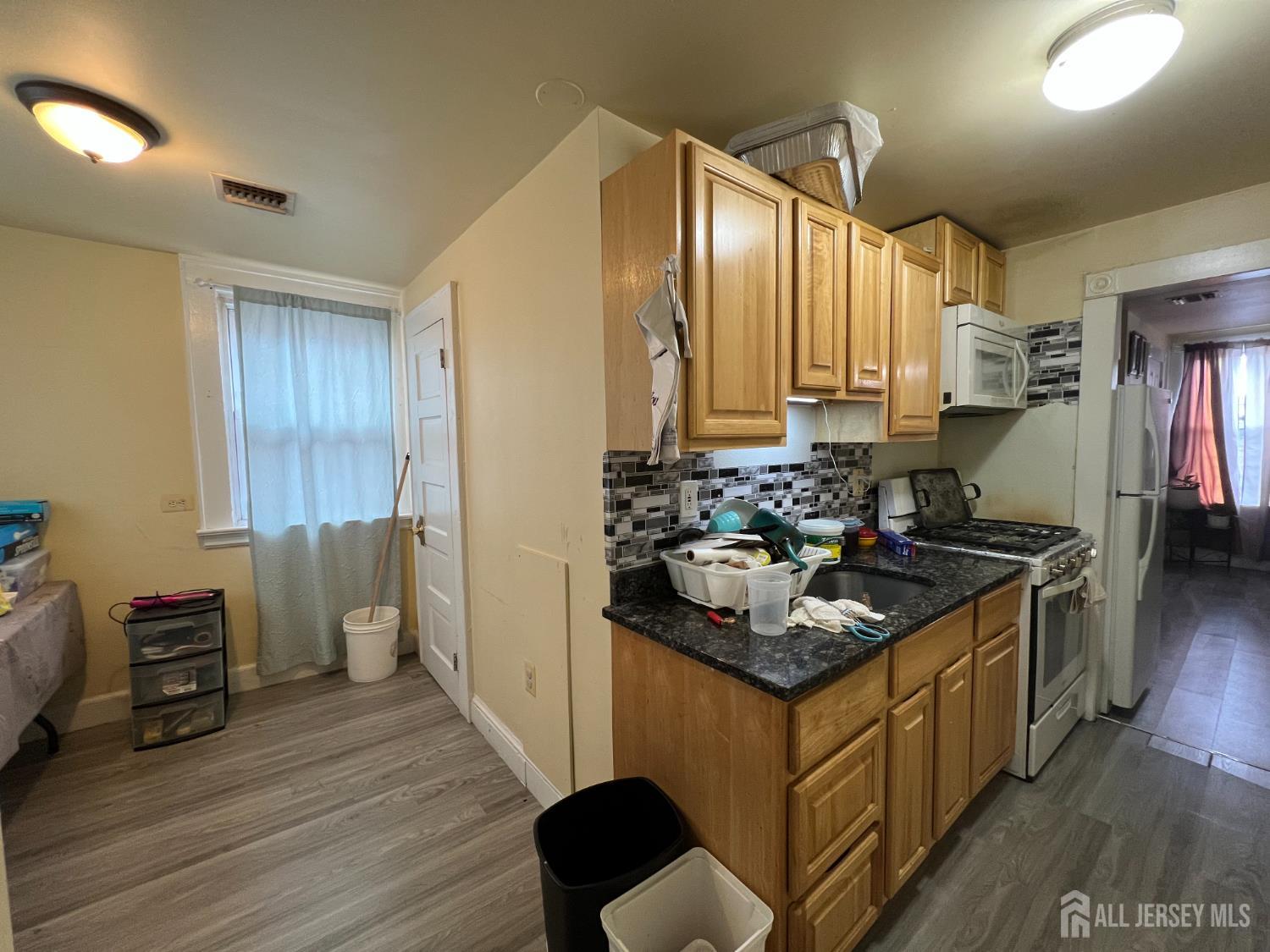 109 Washington Street, Unit 2 Perth Amboy, NJ 08861 - Photo 6 of 12 a kitchen with stainless steel appliances granite countertop a sink stove and cabinets
