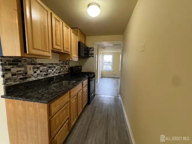 a kitchen with sink a stove and cabinets