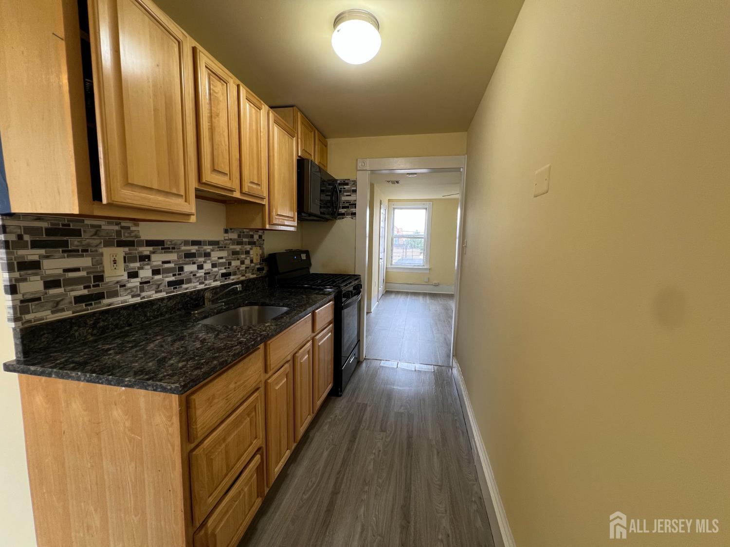 109 Washington Street, Unit 2 Perth Amboy, NJ 08861 - Photo 7 of 15 a kitchen with sink a stove and cabinets