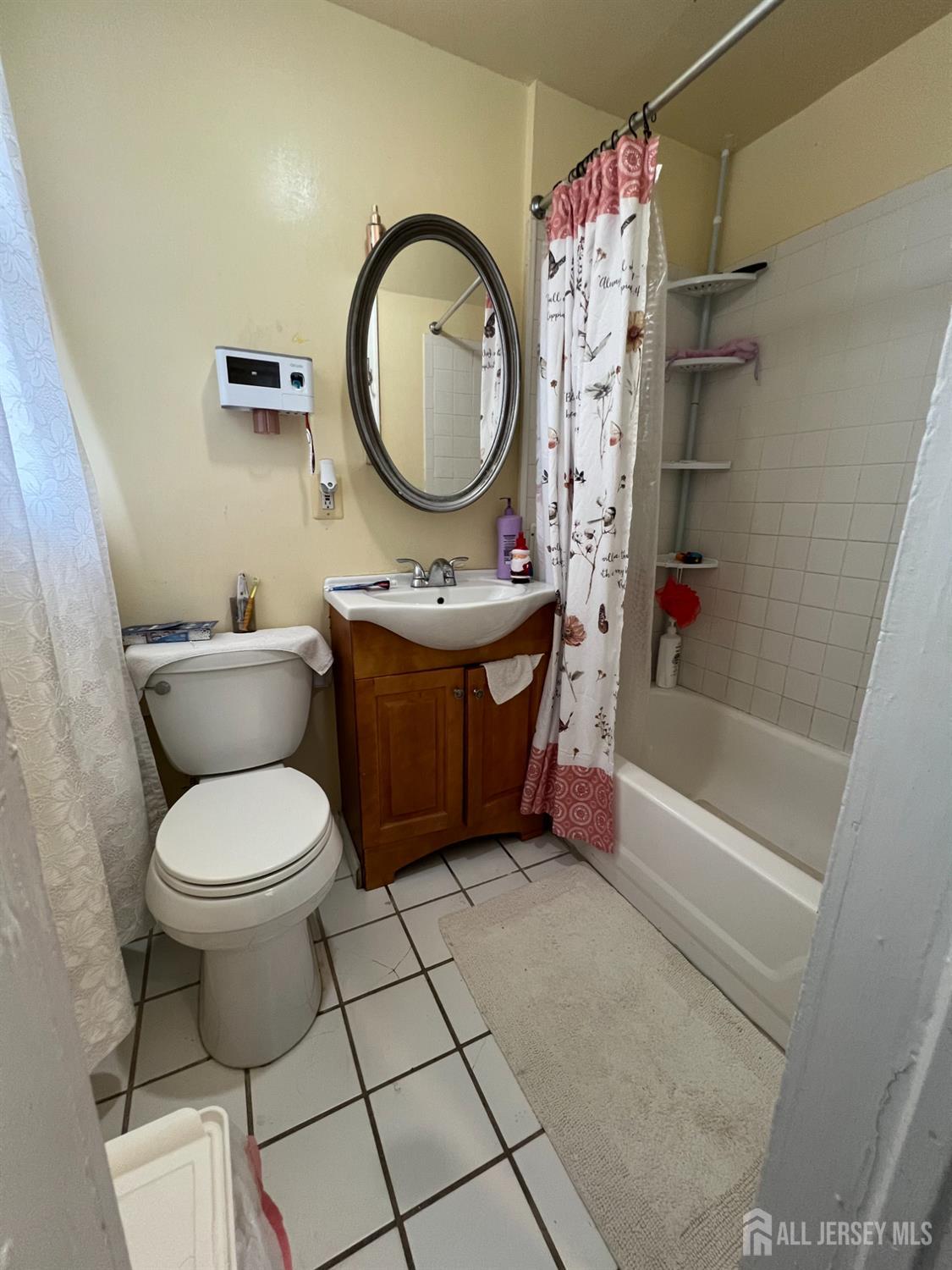 109 Washington Street, Unit 2 Perth Amboy, NJ 08861 - Photo 8 of 12 a bathroom with a bathtub sink mirror vanity and toilet