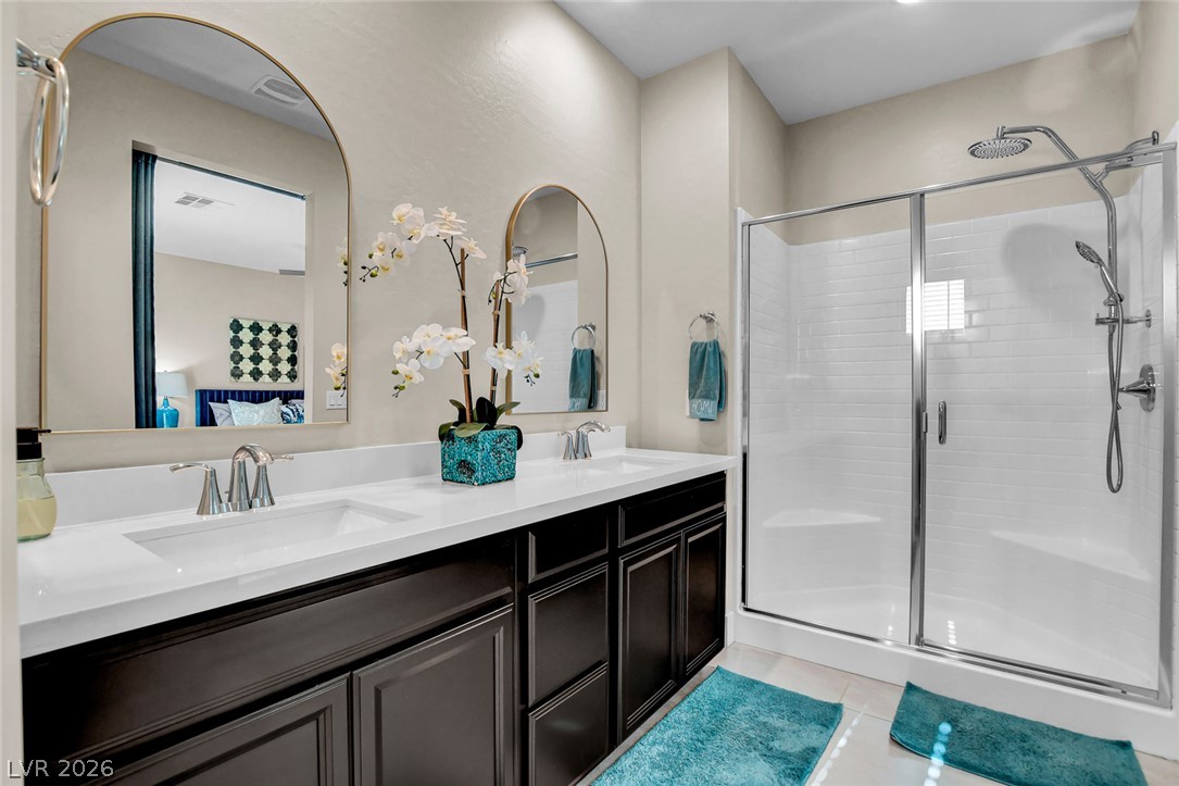 9688 Rankin Rdg Court Las Vegas, NV 89178 - Photo 39 of 53 Dual vanity with pristine countertops and a sleek glass-enclosed shower.