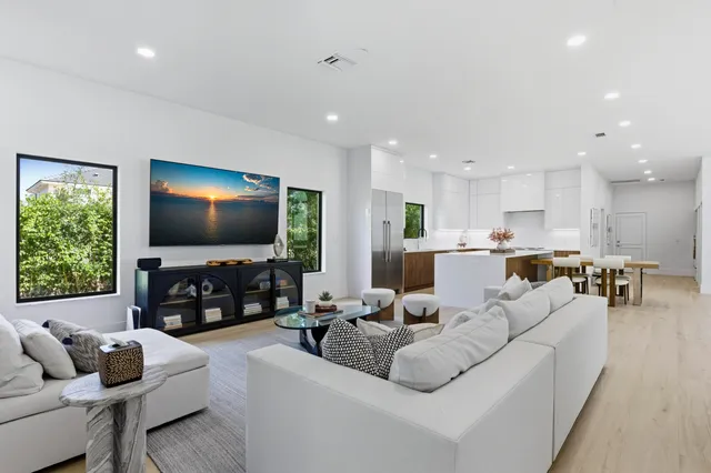 a living room with furniture kitchen view and a flat screen tv
