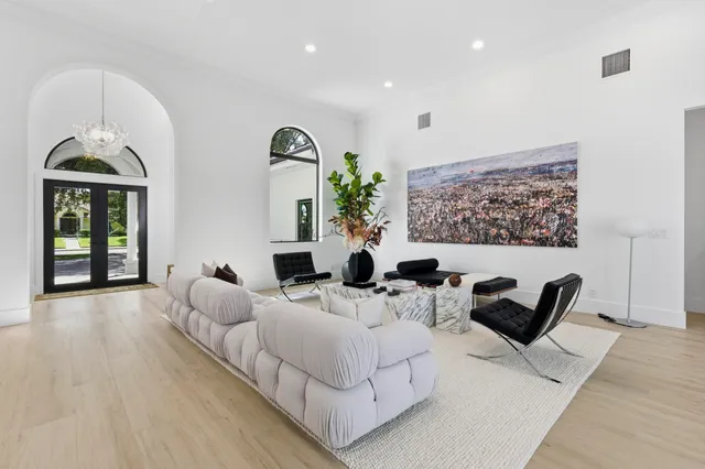 a living room with furniture potted plant and a large window