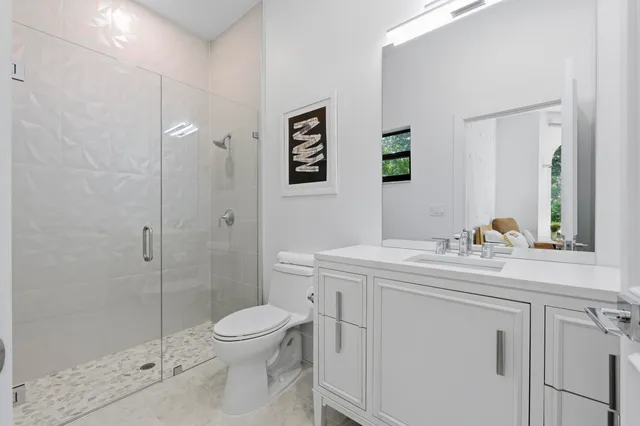 a bathroom with a sink a toilet and shower