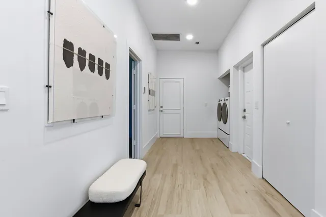a view of a hallway with furniture and wooden floor