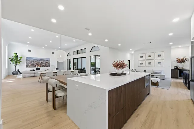 a large kitchen with stainless steel appliances kitchen island a large counter top and a stove top oven