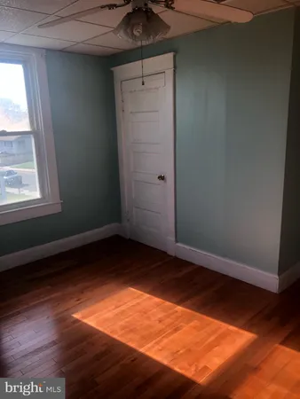 en empty room with wooden floor and windows