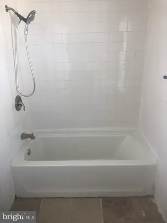 a bathroom with a bath tub with a shower