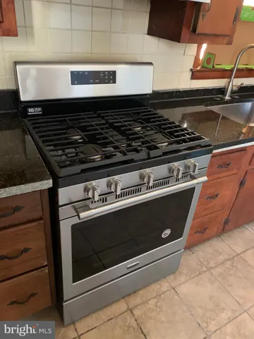 a kitchen with granite countertop a sink and a stove