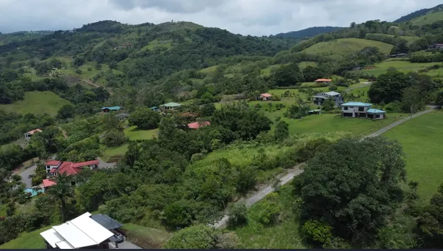 an aerial view of residential house with outdoor space and trees all around