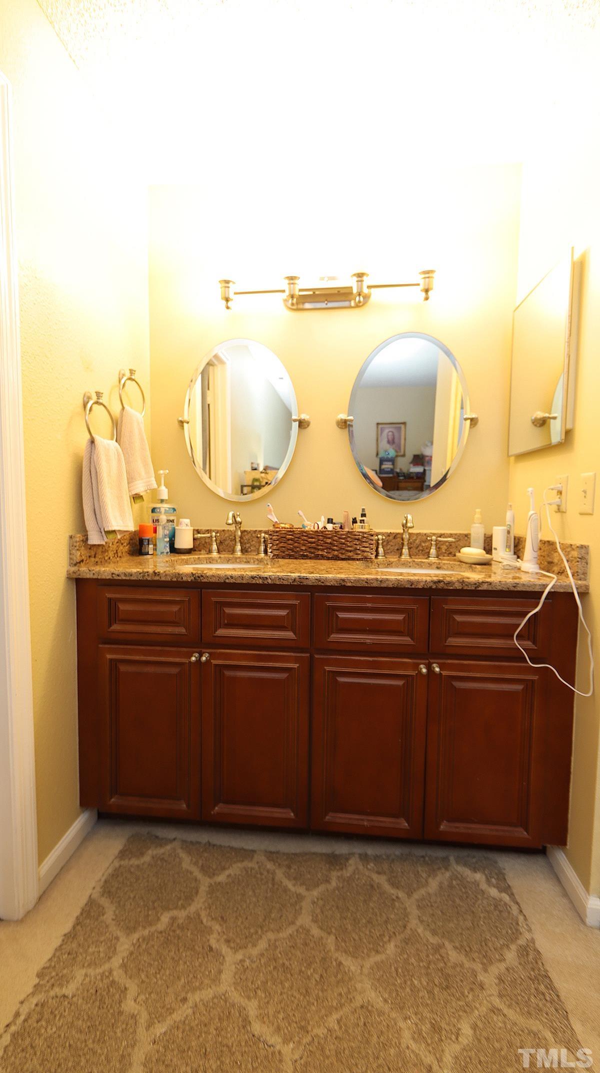 7902 Falcon Rest Circle, Unit 7902 Raleigh, NC 27615 - Photo 8 of 13 a room with a sink and a mirror