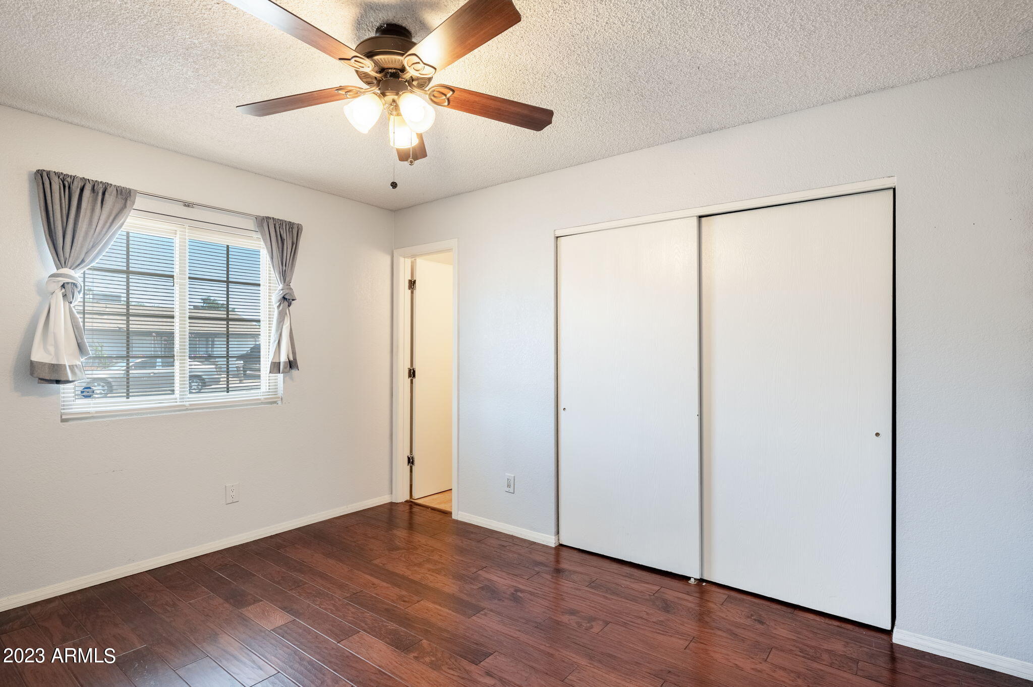 964 West Hackamore Street Mesa, AZ 85201 - Photo 14 of 24 an empty room with wooden floor chandelier fan and windows